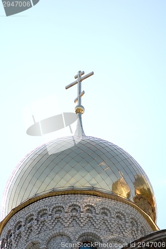 Image of Golden cupola and christian cross on church against blue sky