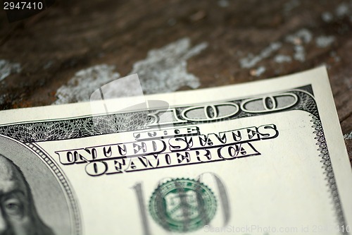 Image of Close-up of a 100 dollars banknotes on wooden background