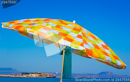 Image of Sunshades and clothes on a sea beach  