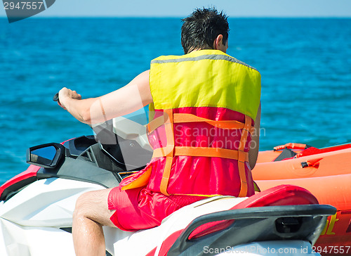 Image of The young man prepares for a sea trip on the water bike.