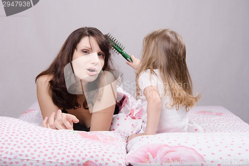 Image of Mom hurt by combing hair daughter