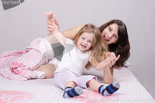 Image of Mom and daughter having fun in the three-year bed