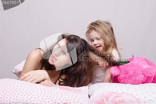 Image of My mother is very sick. Daughter combing her hair