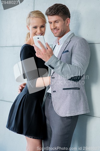 Image of Elegant couple reading a text message on mobile