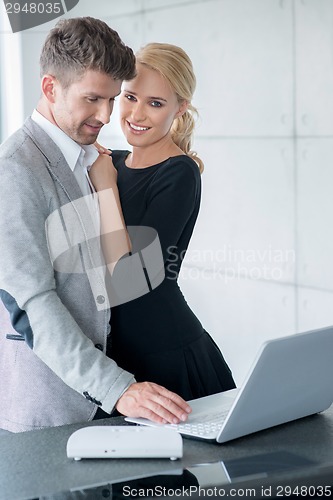 Image of Lovers in Trendy Attire Testing Displayed Laptop