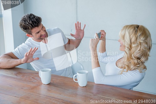 Image of Blond woman photographing her husband