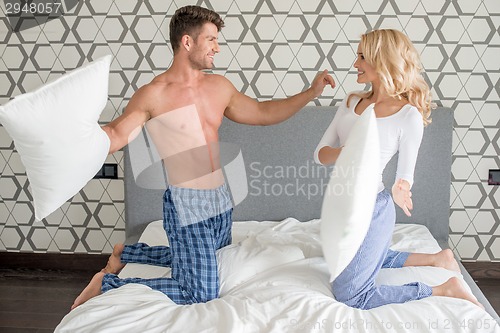 Image of Couple in their sleepwear having a pillow fight