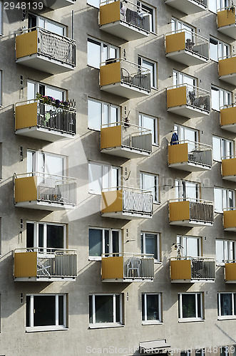 Image of sunlit facade of high-rise building with balconies