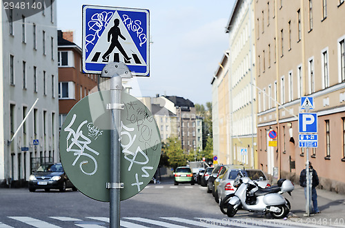 Image of road signs with graffiti at a crossroads