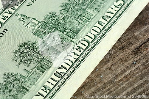 Image of Close-up of a 100 dollars banknotes on wooden background