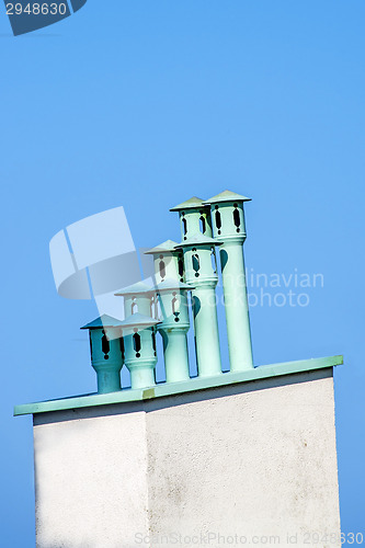 Image of chimneys on a roof with a blue sky