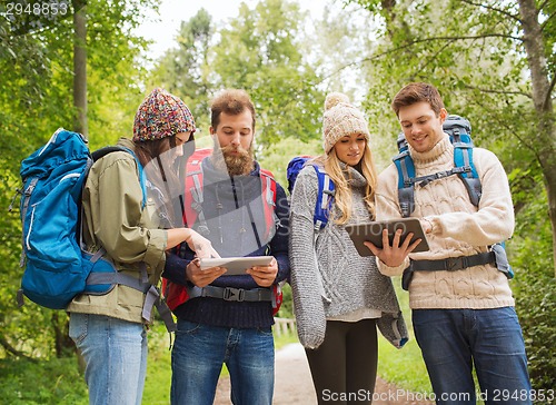 Image of group of friends with backpacks and tablet pc