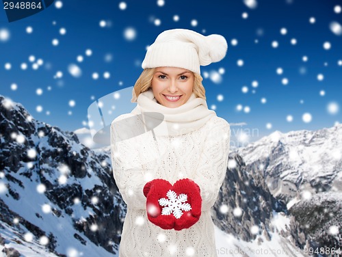 Image of smiling woman in winter clothes with snowflake