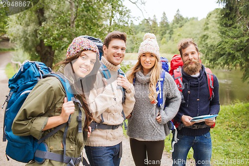 Image of group of smiling friends with backpacks hiking