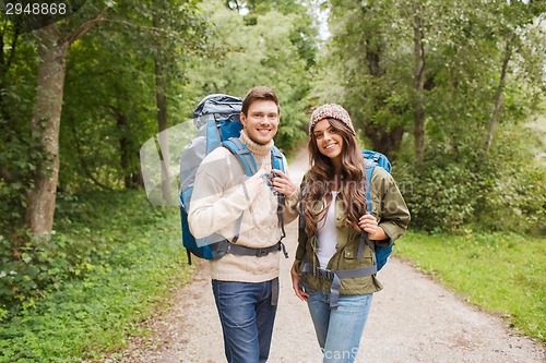 Image of smiling couple with backpacks hiking