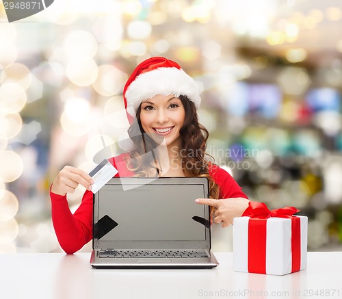 Image of smiling woman with credit card and laptop