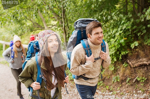 Image of group of smiling friends with backpacks hiking