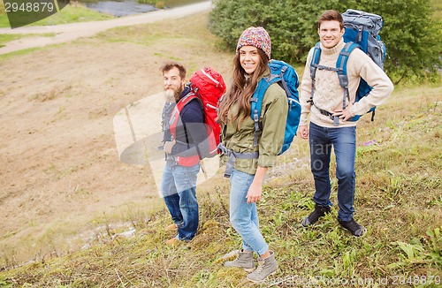 Image of group of smiling friends with backpacks hiking