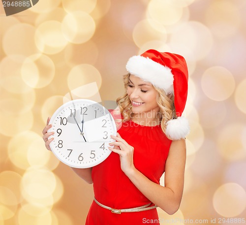 Image of smiling woman in santa helper hat with clock