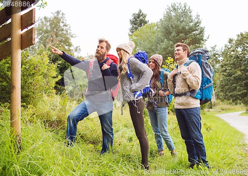 Image of group of smiling friends with backpacks hiking