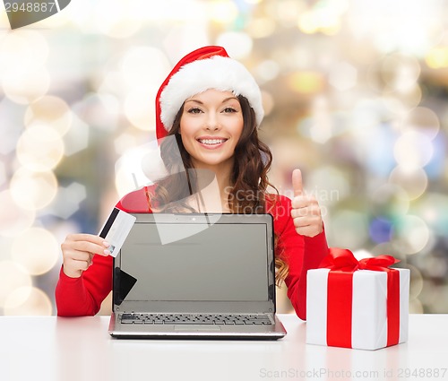 Image of smiling woman with credit card and laptop