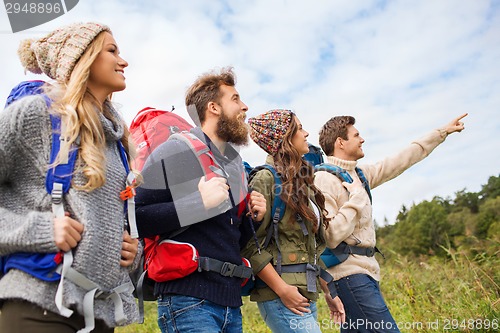 Image of group of smiling friends with backpacks hiking