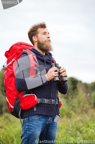 Image of man with backpack and binocular outdoors