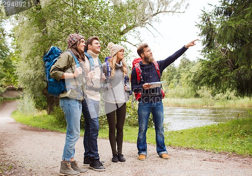 Image of group of smiling friends with backpacks hiking