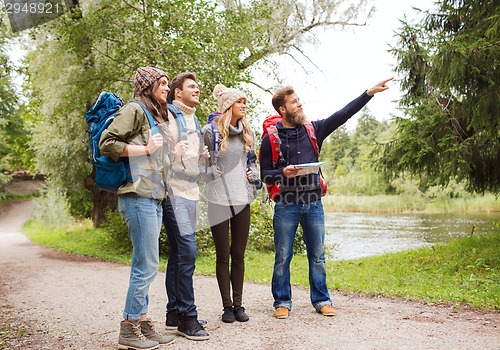 Image of group of smiling friends with backpacks hiking