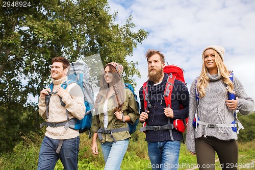 Image of group of smiling friends with backpacks hiking