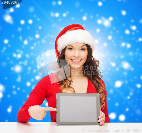 Image of smiling woman in santa hat with gift and tablet pc