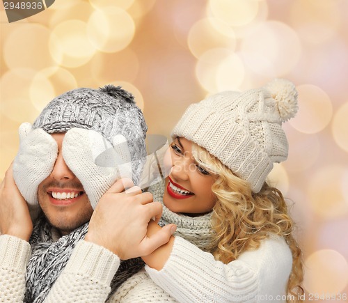 Image of smiling couple in sweaters and santa helper hats