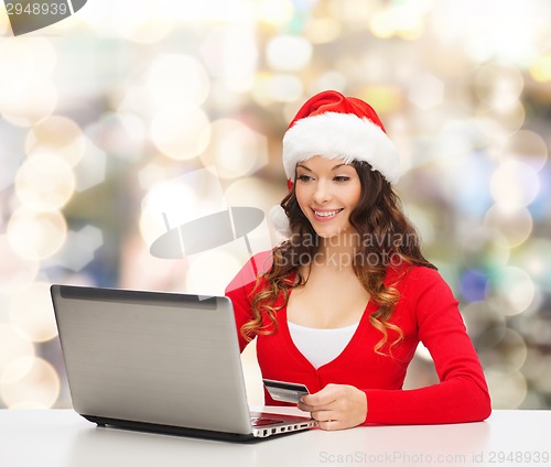 Image of smiling woman with credit card and laptop