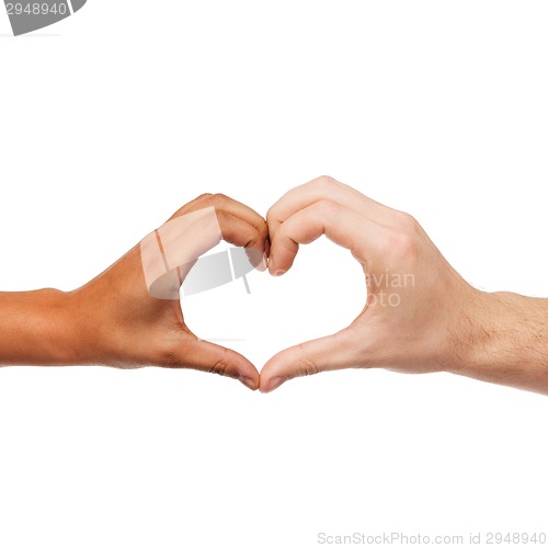 Image of woman and man hands showing heart shape