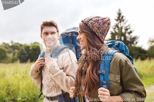 Image of smiling couple with backpacks hiking