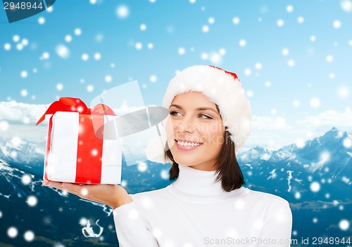 Image of smiling woman in santa helper hat with gift box