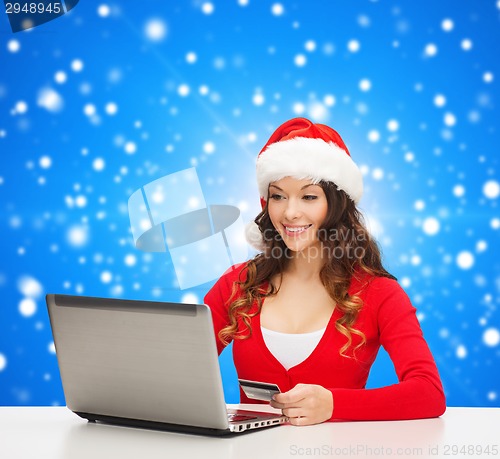 Image of smiling woman with credit card and laptop