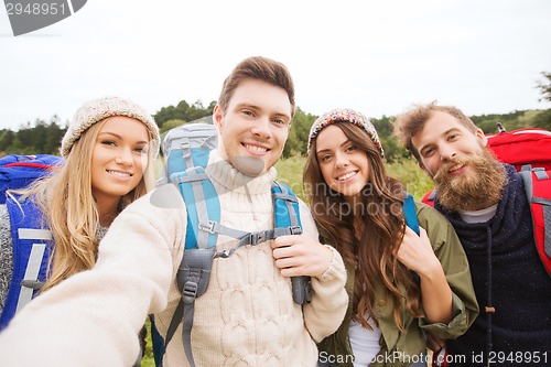 Image of group of smiling friends with backpacks hiking