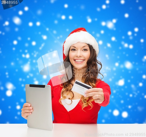 Image of woman in santa hat with tablet pc and credit card