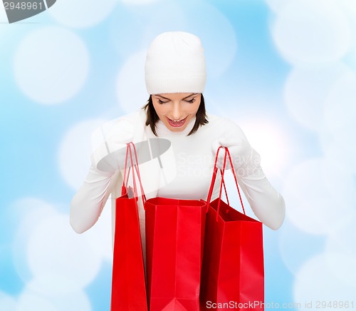 Image of smiling young woman with red shopping bags