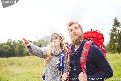 Image of smiling couple with backpacks hiking