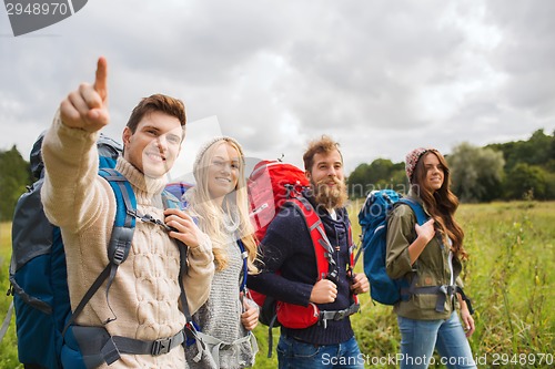 Image of group of smiling friends with backpacks hiking