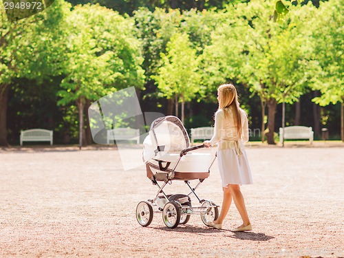 Image of happy mother with stroller in park