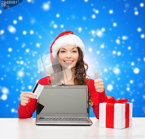Image of smiling woman with credit card and laptop