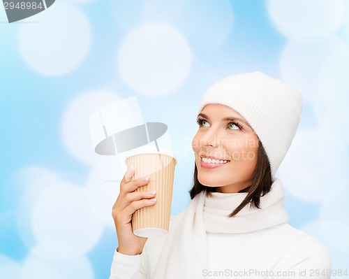 Image of smiling young woman in winter clothes with cup