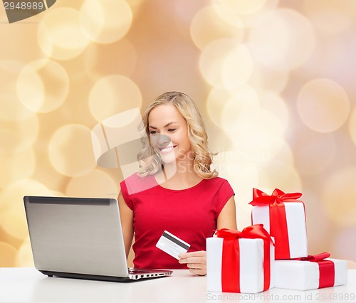 Image of smiling woman with credit card and laptop