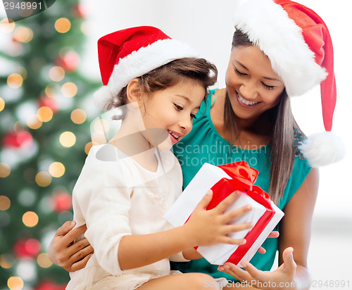 Image of happy mother and child girl with gift box