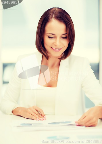 Image of businesswoman working with graphs in office