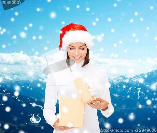 Image of smiling woman in santa helper hat with gift box