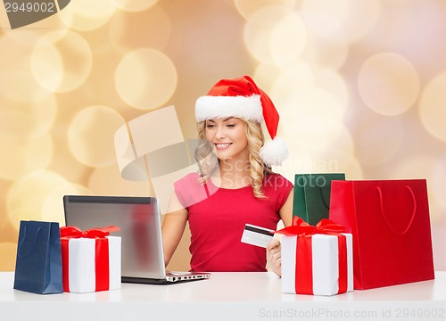 Image of smiling woman with credit card and laptop